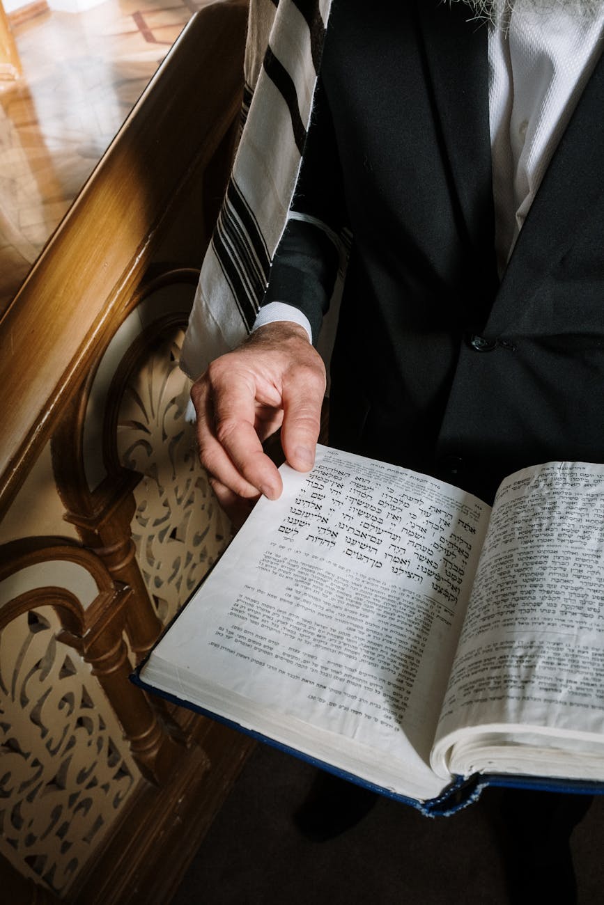 person in black suit holding a book